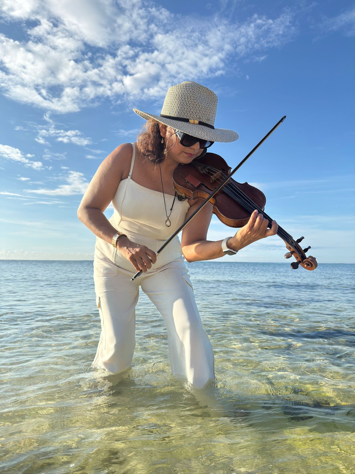 Elena Luna tocando el violín en la playa